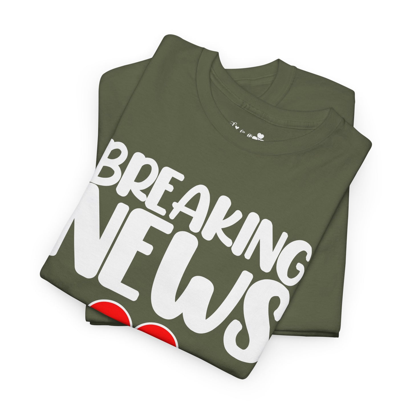 Folded green t-shirt with 'BREAKING NEWS' text on a white background
