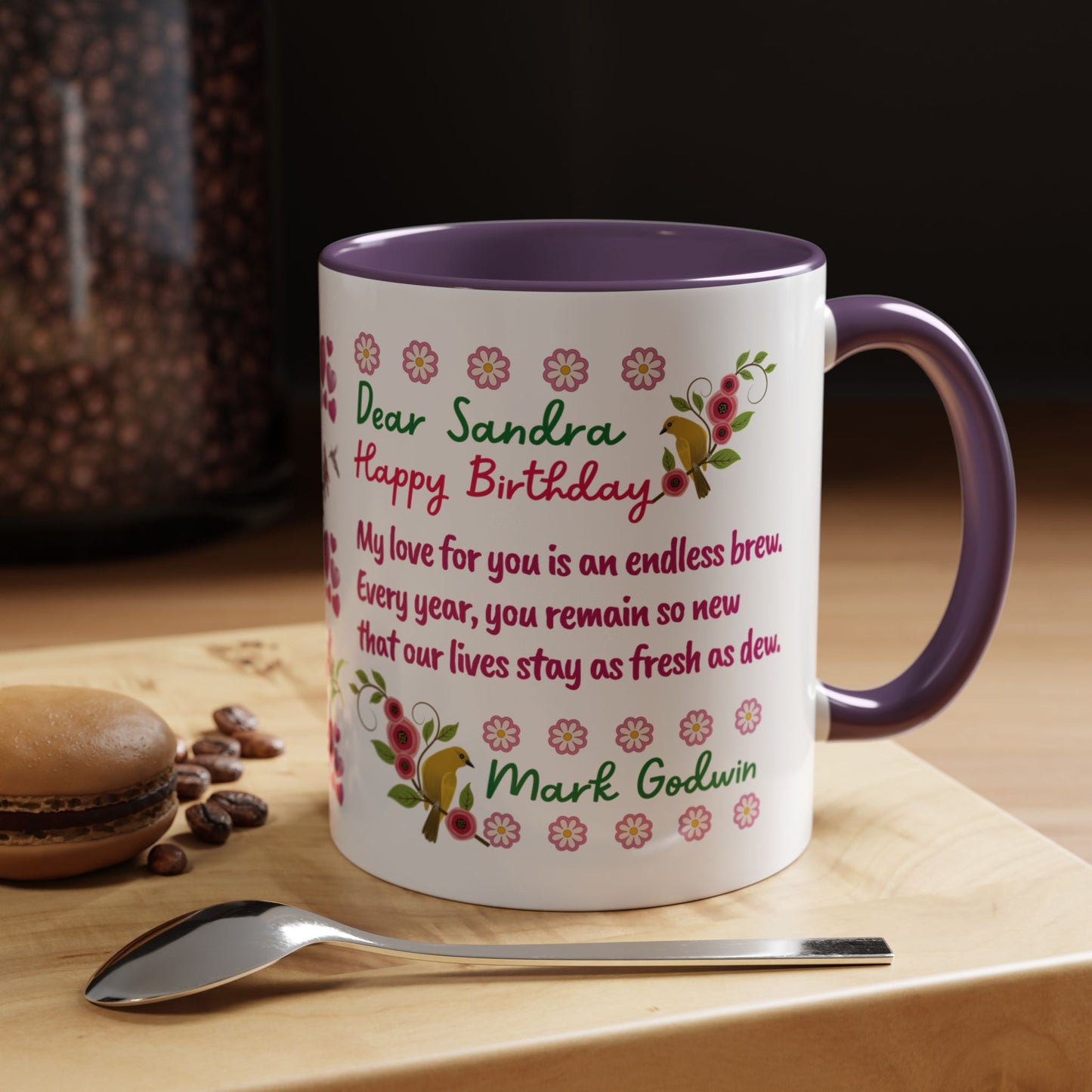 Personalized Birthday Mug for Wives. Personalized birthday mug with floral design and text on a wooden surface with coffee beans and a macaron.