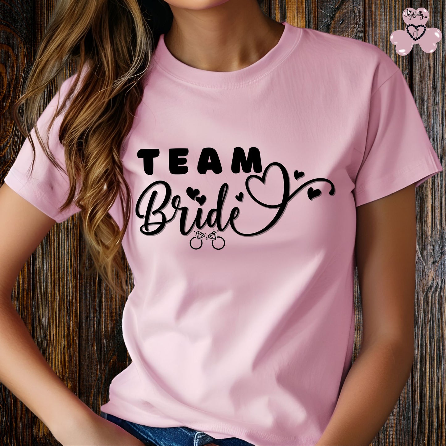 Shirt for Engagements, Bachelorettes, Hen and Bridal Parties. Person wearing a pink t-shirt with 'Team Bride' text on a wooden background