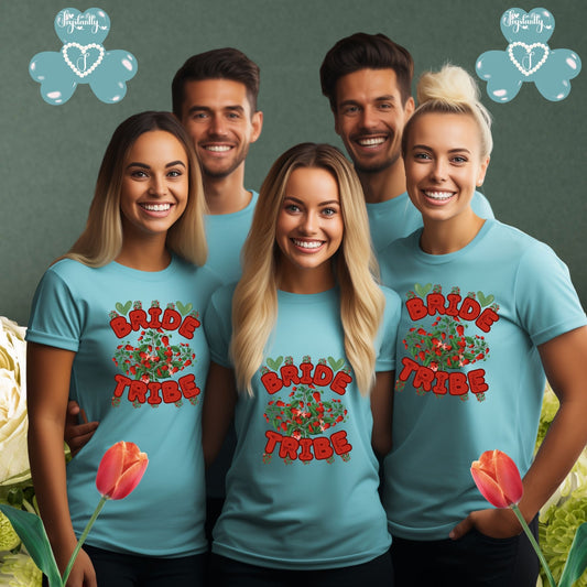 Group of people wearing 'Bride Tribe' shirts with floral designs, standing against a green background.