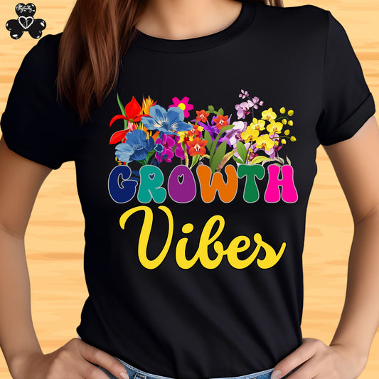 Motivational T-shirt for positive affirmations. Black t-shirt with colorful floral design and 'Growth Vibes' text on a wooden surface