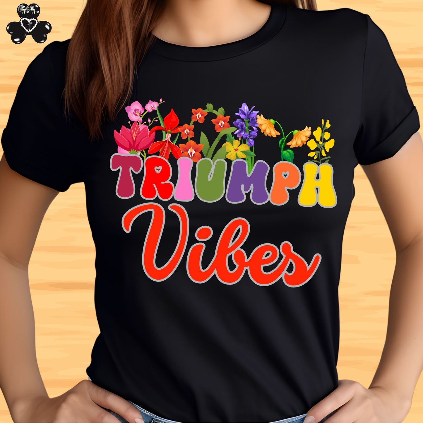 Motivational T-shirt for positive affirmations. Black t-shirt with colorful 'Triumph Vibes' design on a wooden surface