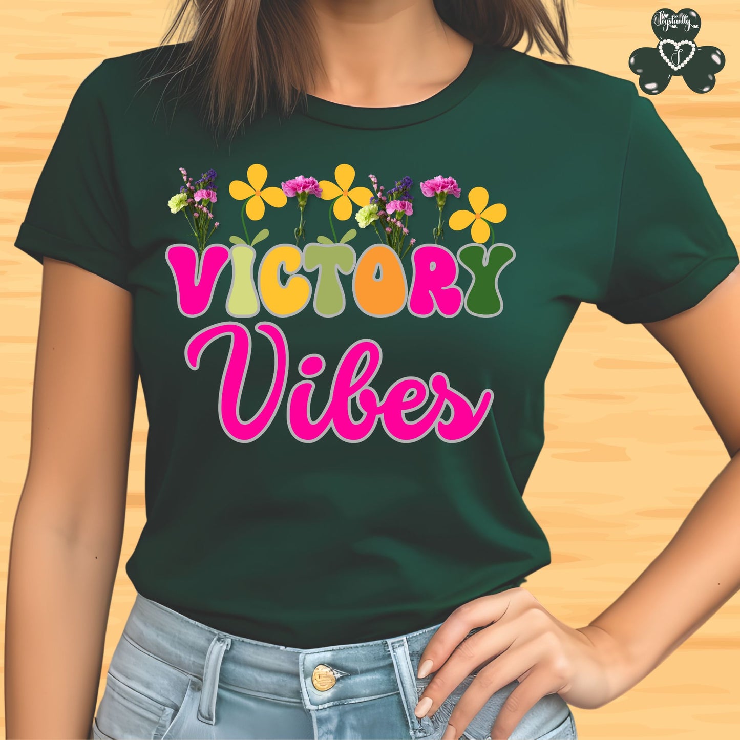 Motivational T-shirt for positive affirmations. Green t-shirt with 'Victory Vibes' text and flowers on a wooden surface