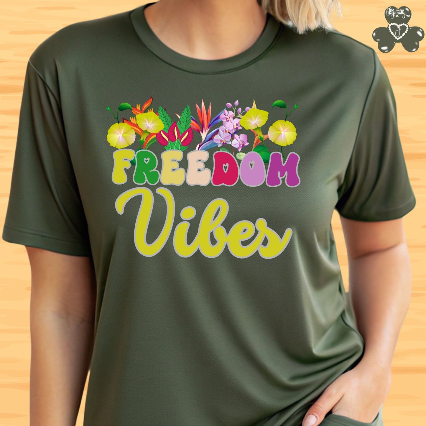 Motivational shirt. Green t-shirt with 'Freedom Vibes' text and floral design on a wooden background