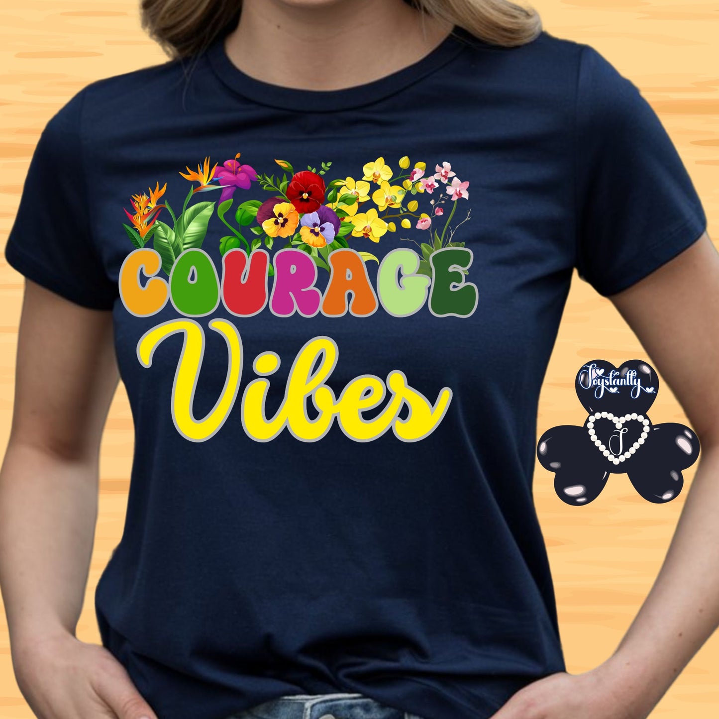 Motivational shirt. Navy blue t-shirt with colorful 'Courage Vibes' design on a wooden surface