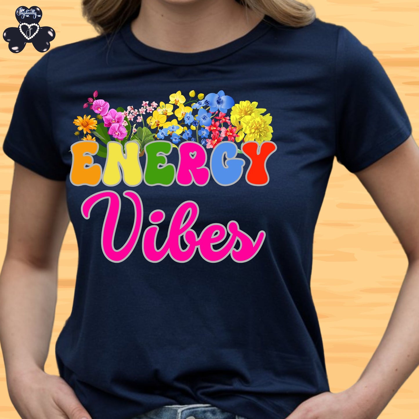 Motivational Shirts for Positive Affirmations. Navy blue t-shirt with colorful floral design and 'ENERGY Vibes' text on a wooden surface