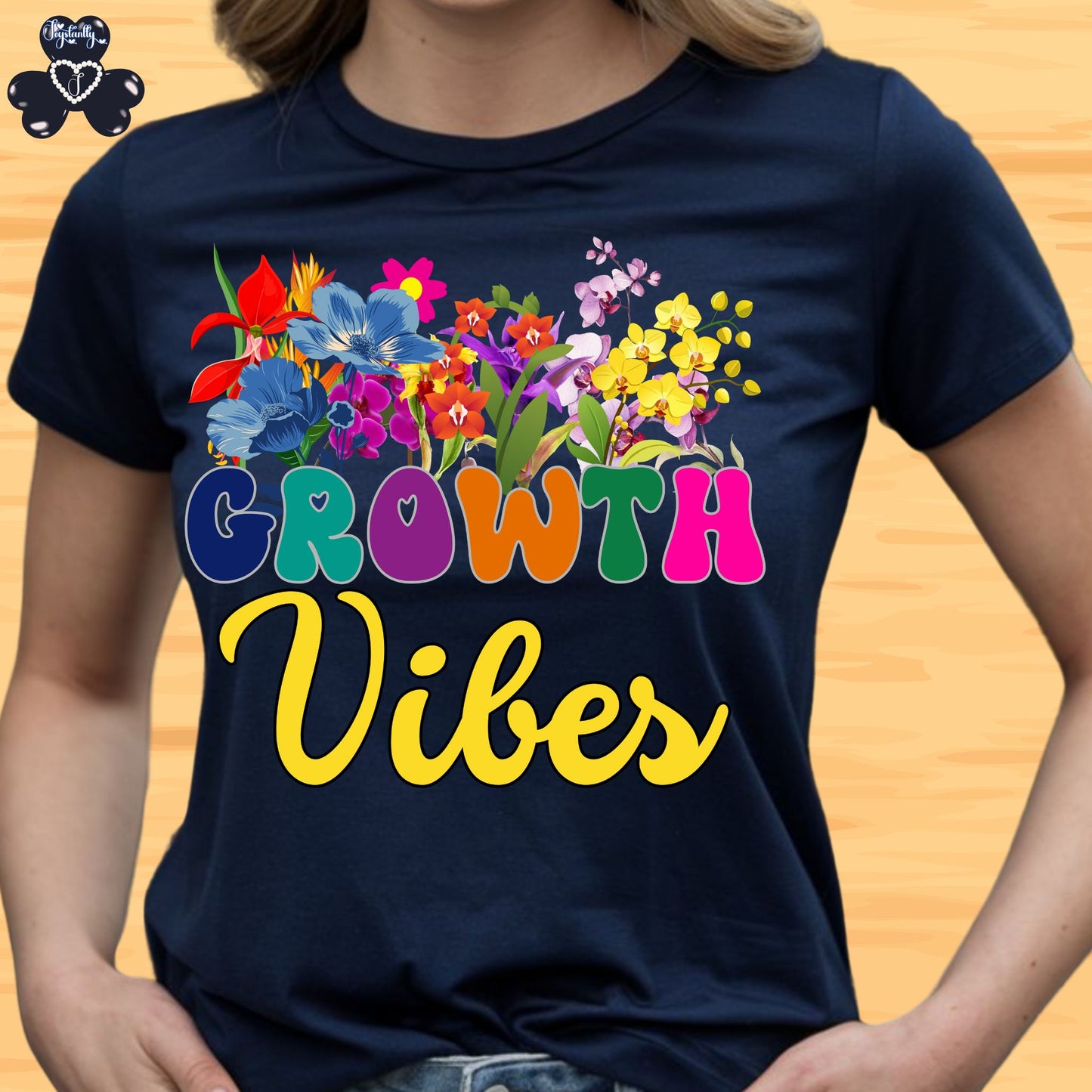 Motivational T-shirt for positive affirmations. Navy blue t-shirt with colorful floral design and 'Growth Vibes' text on a wooden surface.