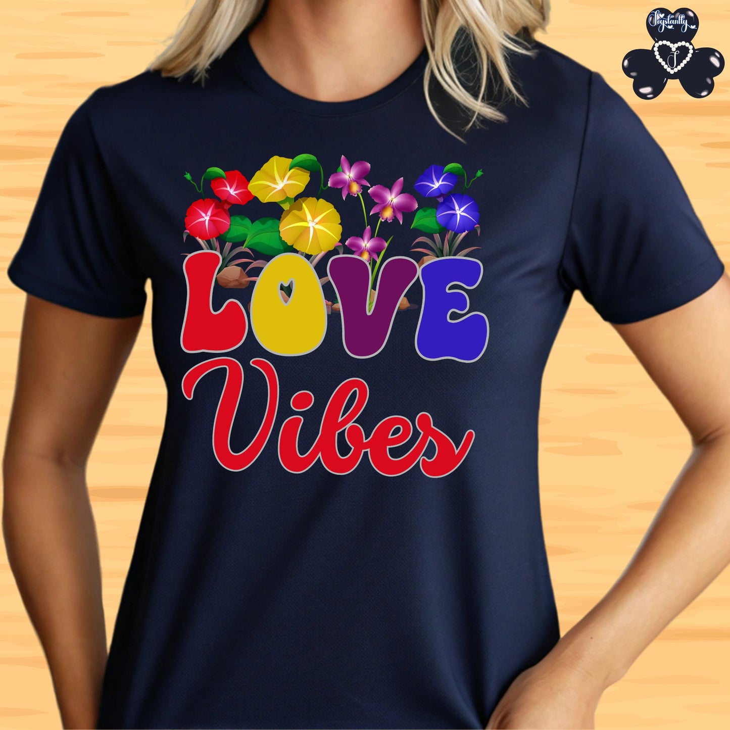 Motivational T-shirt for positive affirmations. Navy blue t-shirt with colorful 'LOVE Vibes' design on a wooden surface