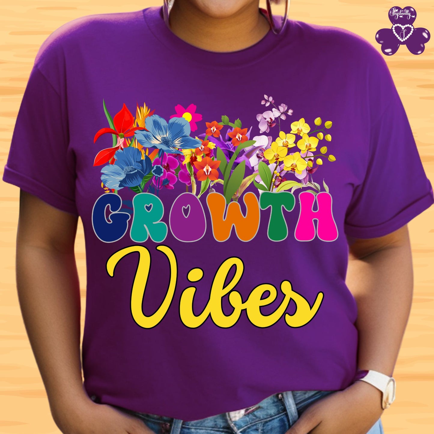Motivational T-shirt for positive affirmations. Person wearing a purple t-shirt with colorful floral design and 'Growth Vibes' text on a wooden background.