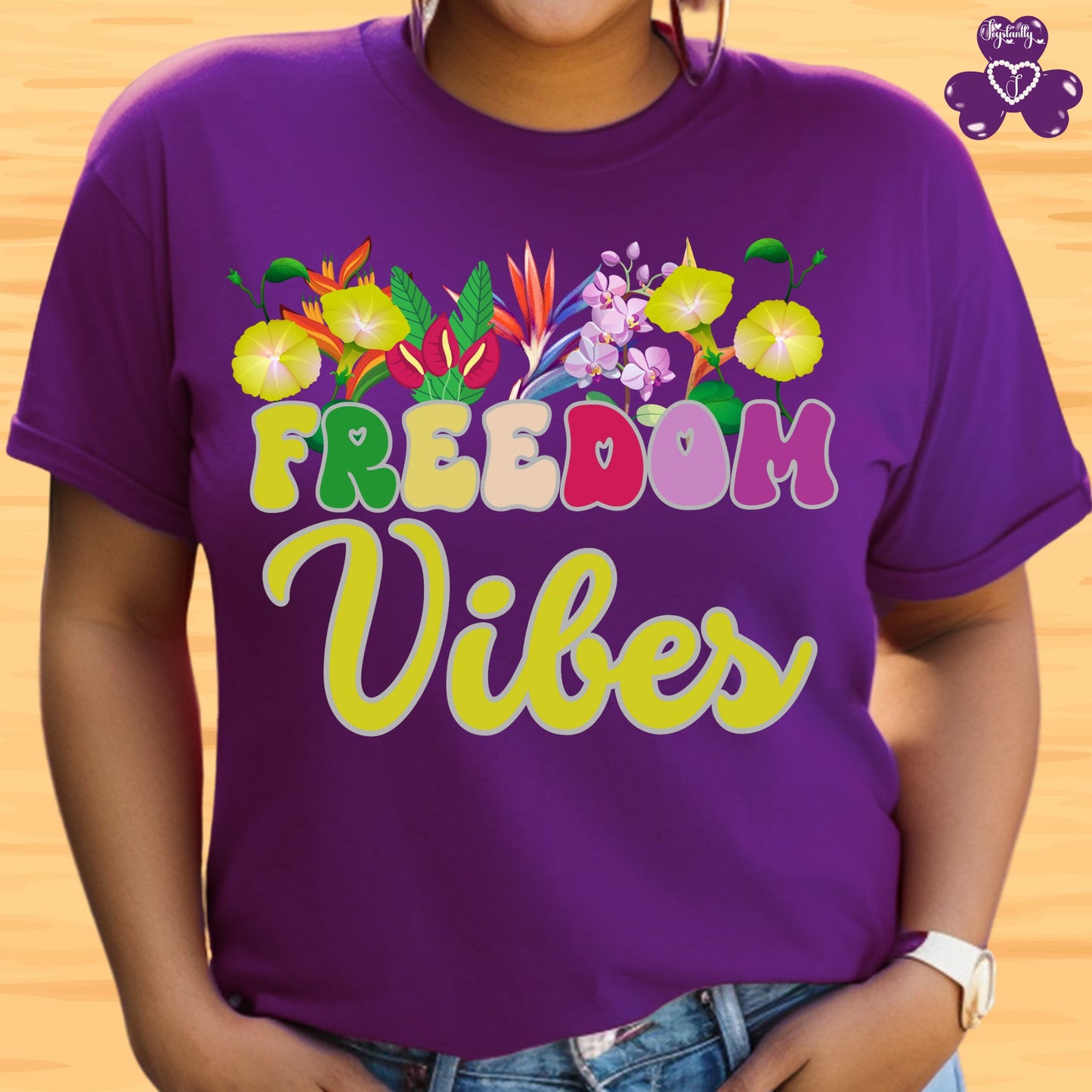 Motivational T-shirt for positive affirmations. Purple t-shirt with 'Freedom Vibes' text and floral design on a wooden background