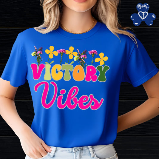 Motivational T-shirt for positive affirmations. Person wearing a blue t-shirt with 'Victory Vibes' and floral designs.