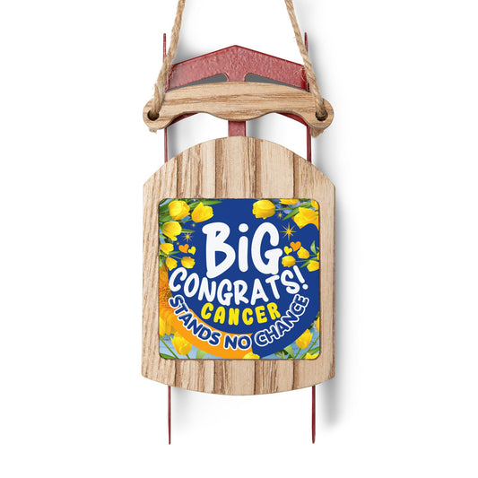 Victory Over Cancer Sled Ornament. Wooden sled with a colorful sign reading 'Big Congrats! Cancer Stands No Chance' on a white background