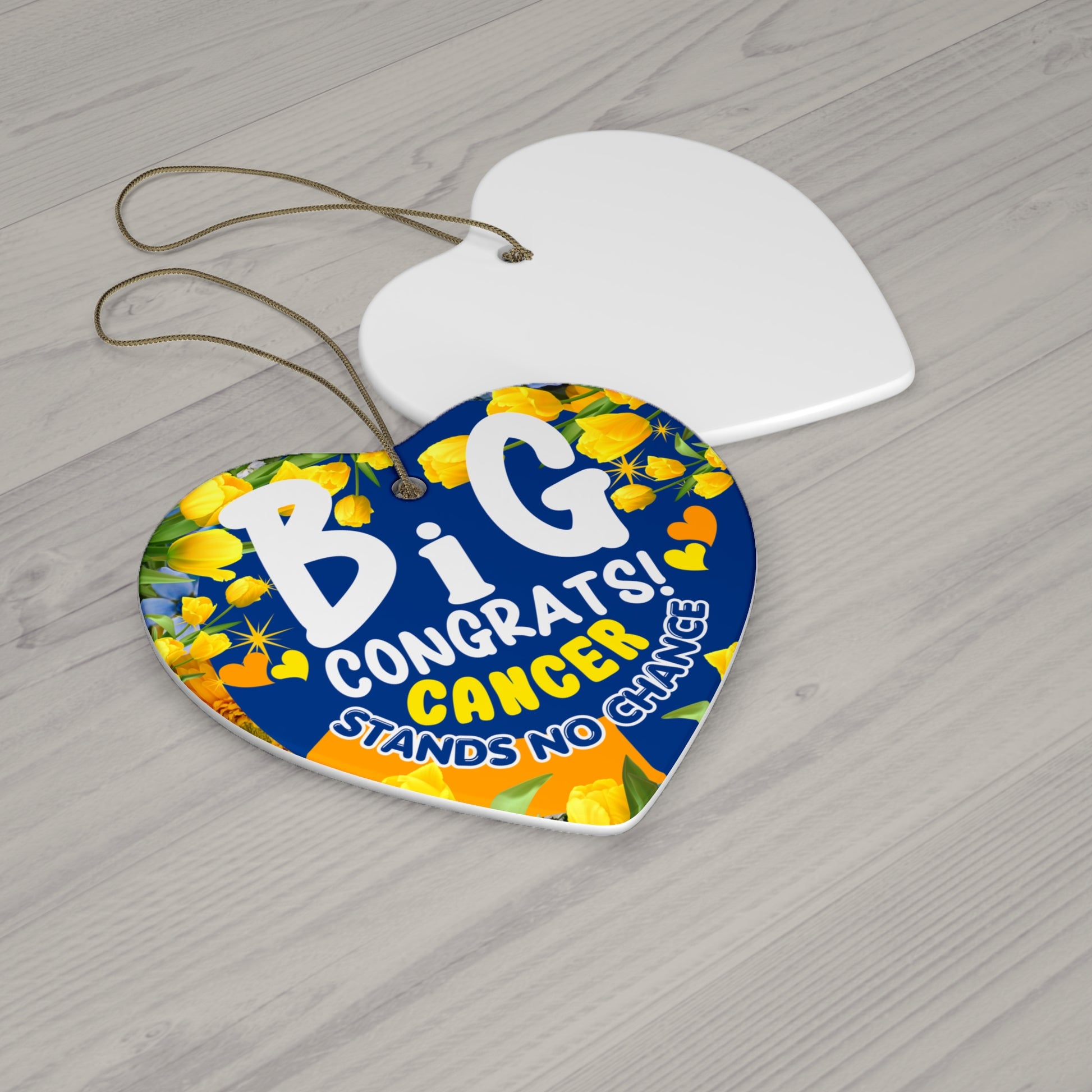 Cancer Motivational Ceramic Ornament of Victory. Heart-shaped decorative tag with floral design and text on a wooden surface