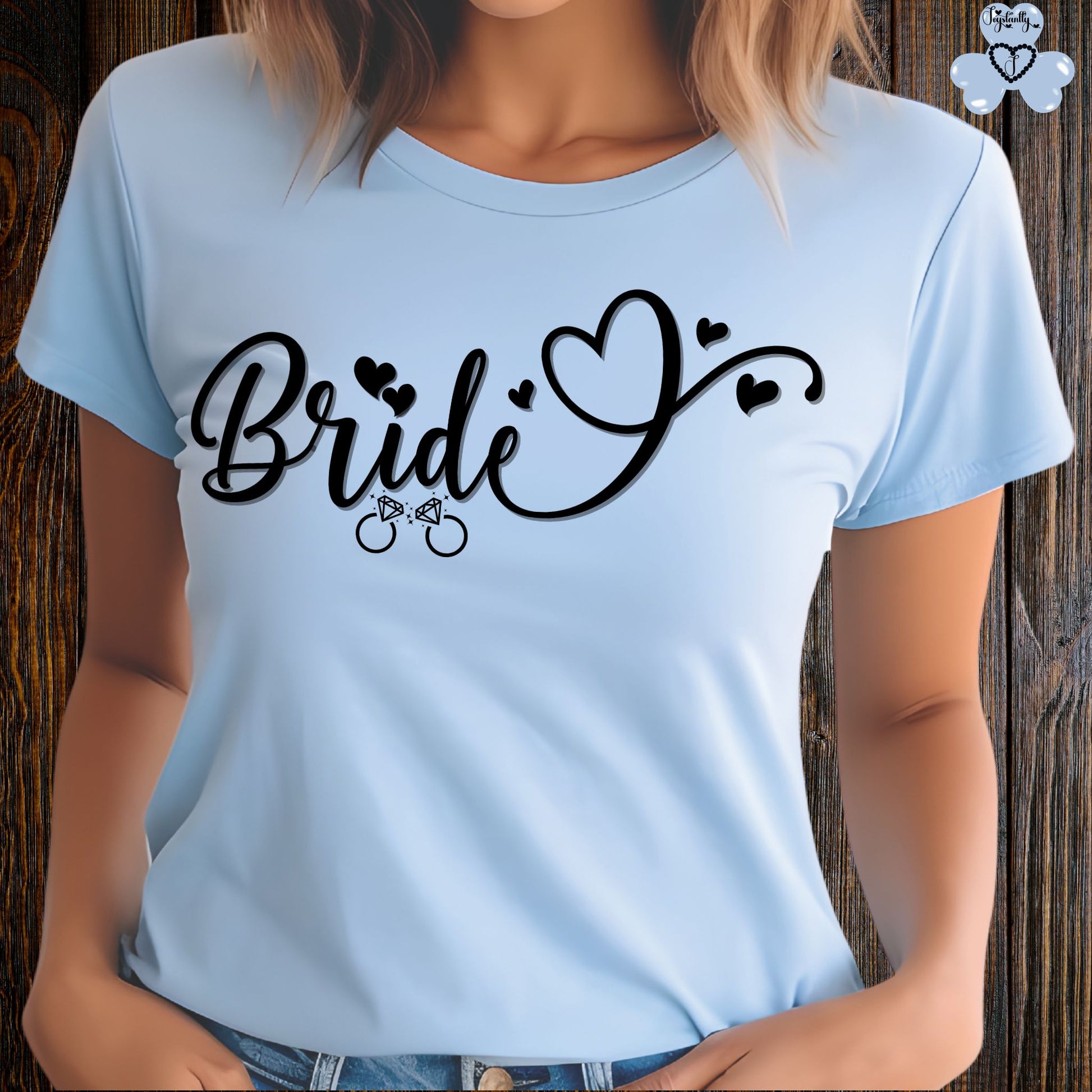 Super Shirt for Engagements, Bachelorettes, Hen and Bridal Parties. Light blue t-shirt with 'Bride' text and heart designs on a wooden background