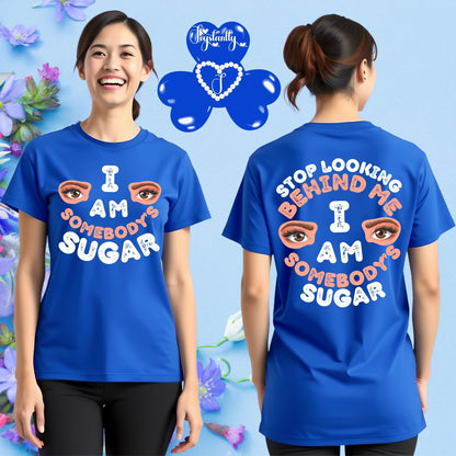 Person wearing a blue t-shirt with text and eye graphics, standing against a floral background.
