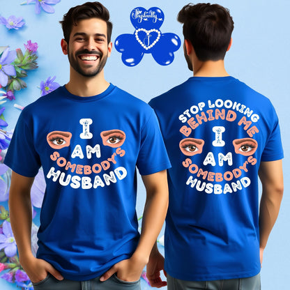 Man wearing a blue t-shirt with text 'I AM SOMEBODY'S HUSBAND' on front and back, with a colorful floral background.