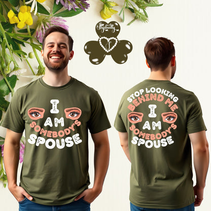 Person wearing a green t-shirt with a humorous message, surrounded by flowers and leaves.