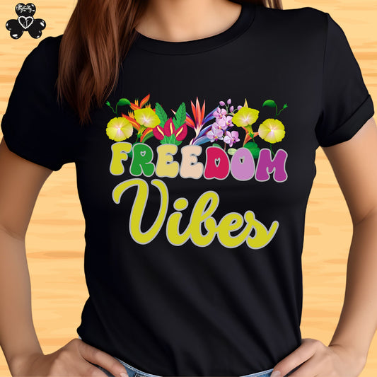 Motivational shirt. Black t-shirt with colorful floral design and 'Freedom Vibes' text on a wooden surface