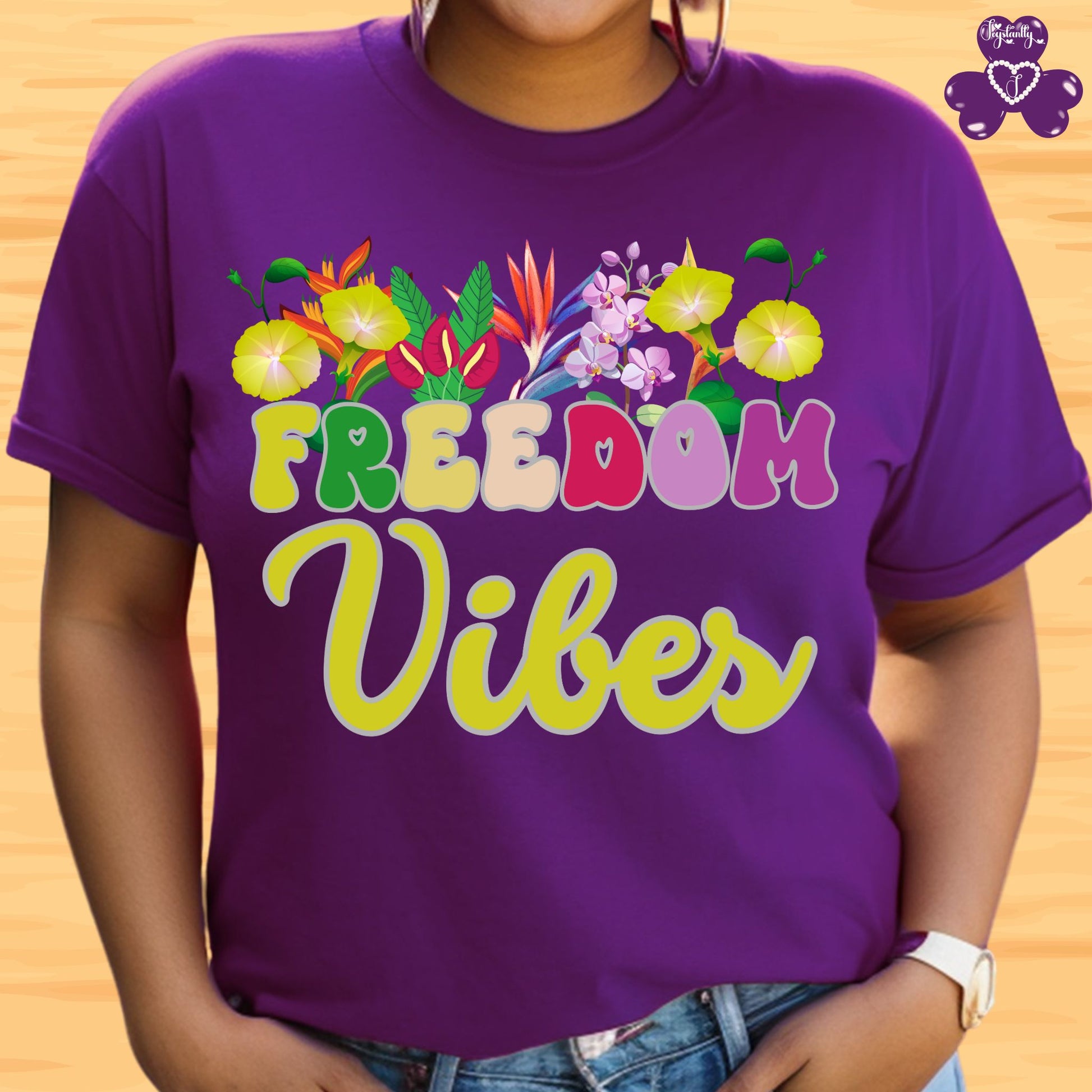 Motivational T-shirt for positive affirmations. Purple t-shirt with 'Freedom Vibes' text and floral design on a wooden background