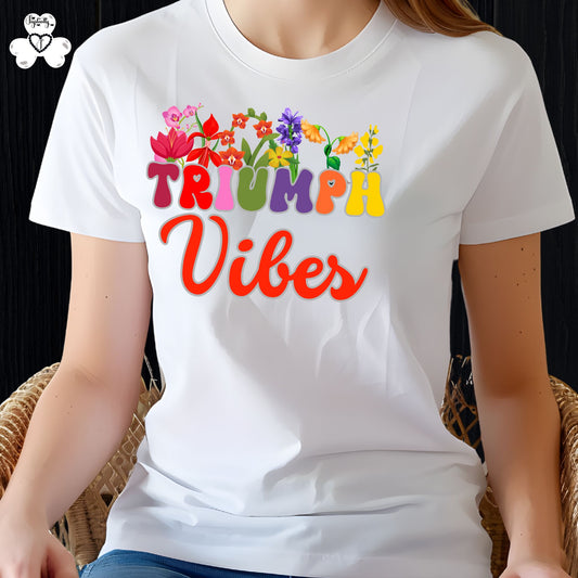Motivational T-shirt for positive affirmations. White t-shirt with colorful 'Triumph Vibes' design on a person sitting in a chair.